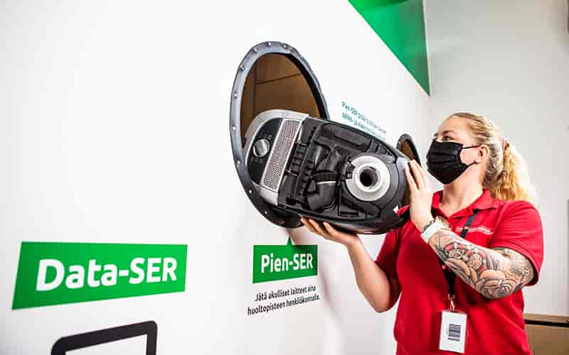 Employee sorts a vacuum cleaner to electronics disposal