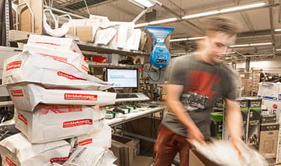 Postittaja pakkaa Verkkokauppa.com tilauksia postipaketteihin