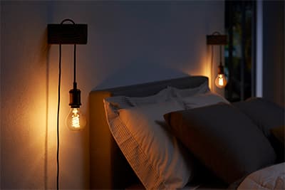 Tunnelmalliset Philips Hue -lamput sängyn vieressä