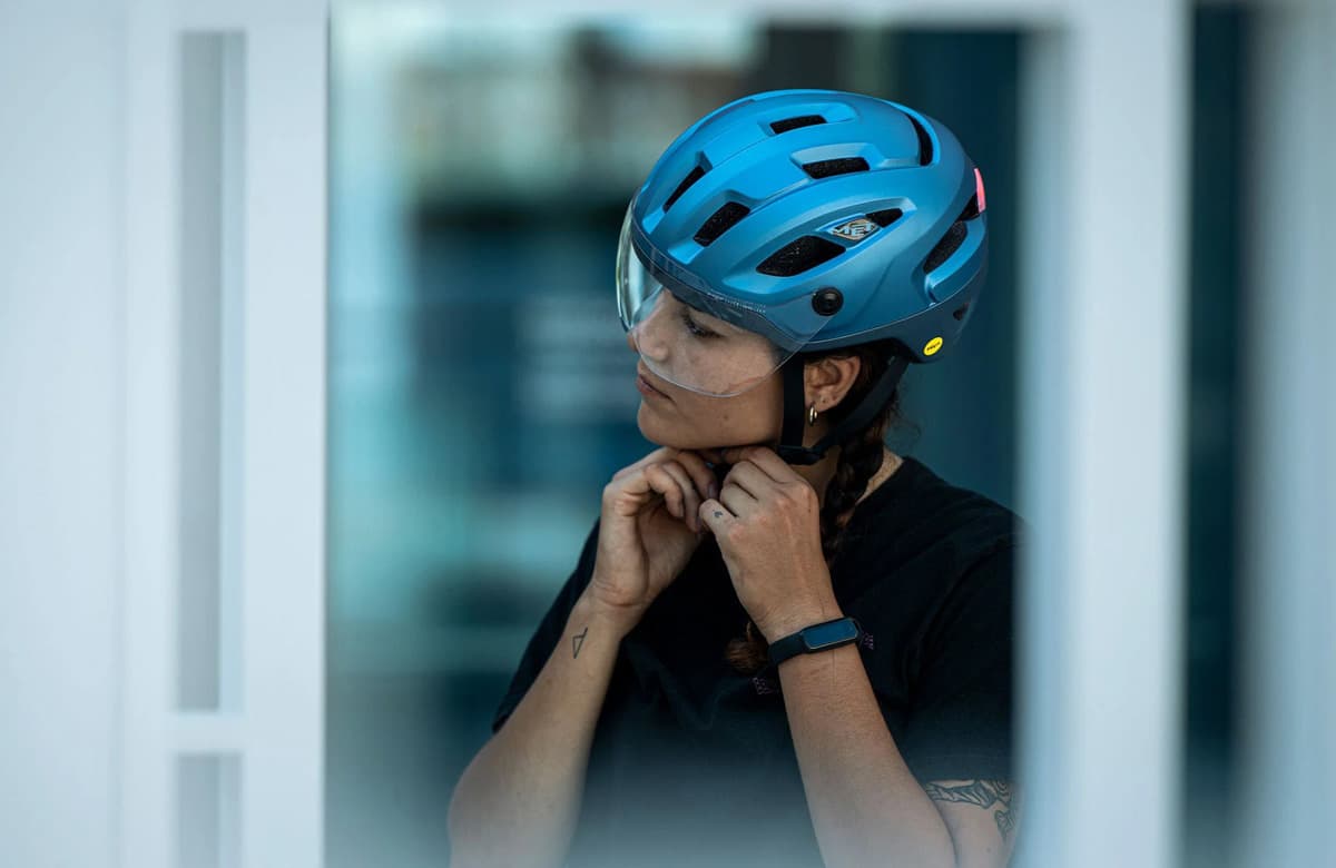 Nainen kiinnittää pyöräilykypärää. Kuva: Met