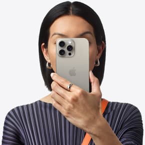 Henkilö pitelee iPhone 15 Pro Maxia kasvojensa edessä