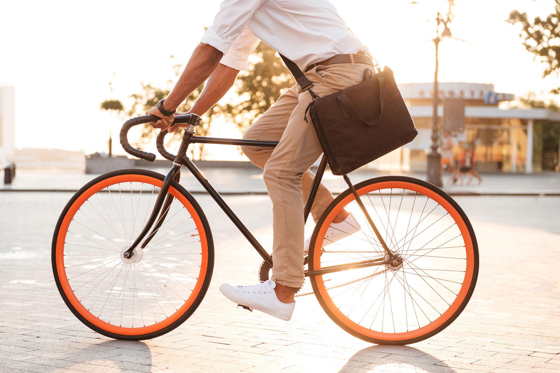 Pyoräilijä pyöräilee aurinkoisella säällä kaupungilla