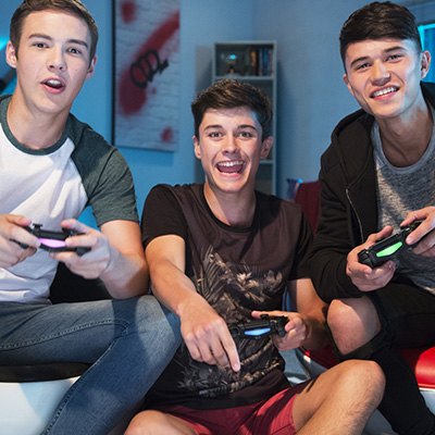 Porukka pelaamassa ja Playstation-ohjaimet
