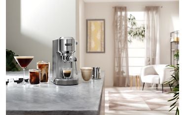 DeLonghi Dedica Duo espressokeitin työtasolla ja sen molemmilla puolilla on erilaisia kahvijuomia.
